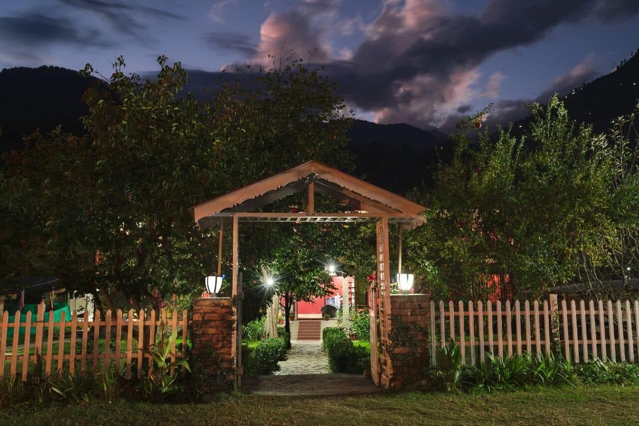 The entrance pergola lit at dusk with mountains behind