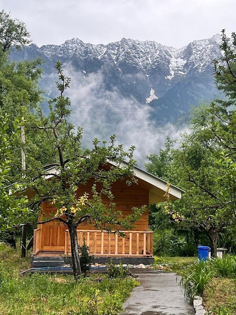 A wooden chalet at Shanag with misty peaks behind