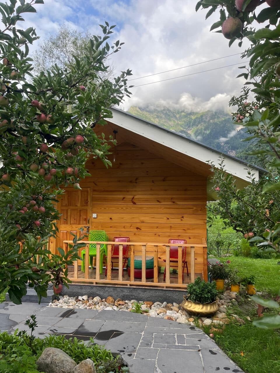 A wooden chalet beside an apple tree and garden