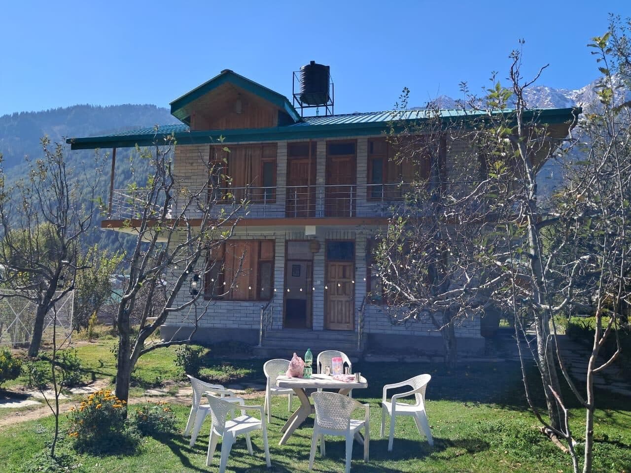 Chairs on the lawn by a chalet and orchard at Shanag