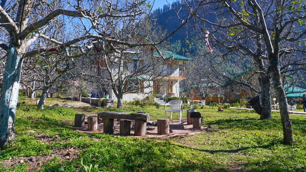 Stone tables set in the orchard among the chalets